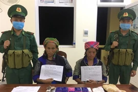 Đối tượng Giàng Thị Thào và Giàng Thị Pàng cùng tang vật vụ án tại cơ quan chức năng. (Ảnh: Xuân Tiến/TTXVN)