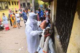 Nhân viên y tế lấy mẫu dịch xét nghiệm COVID-19 cho người dân tại Mumbai, Ấn Độ, ngày 12/10/2020. (Ảnh: AFP/TTXVN) 