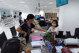 Người dân nộp hồ sơ làm thủ tục tư pháp tại Trung tâm Phục vụ hành chính công tỉnh Tiền Giang. (Ảnh: Minh Hưng/TTXVN)