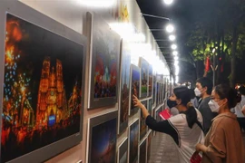 Người dân Thủ đô xem ảnh trưng bày tại một triển lãm. (Ảnh: Nguyễn Thuỳ Dương/TTXVN phát)