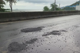 Các vị trí ổ gà liên tiếp nhau trên Quốc lộ 1. (Ảnh: Phan Sáu/TTXVN)