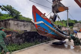 Các lực lượng chức năng hỗ trợ người dân di chuyển tàu, thuyền đến nơi an toàn trên đảo Cồn Cỏ. (Ảnh: TTXVN phát)