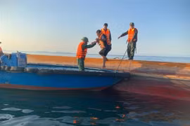 Cán bộ, chiến sỹ Đồn Biên phòng Cát Bà đang ứng cứu thuyền viên bị bạn trên biển. (Ảnh: TTXVN)