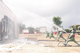 Lực lượng phòng hóa của Việt Nam phun thuốc khử độc tại một vụ rò rỉ khí độc trong một tình huống giả định tại buổi diễn tập. (Ảnh: Phạm Kiên/TTXVN)