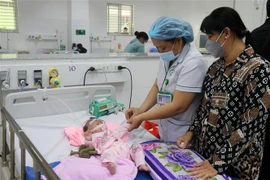 Bác sỹ Bệnh viện Sản-Nhi Kiên Giang khám, điều trị cho trẻ sốt xuất huyết. (Ảnh: Lê Huy Hải/TTXVN)