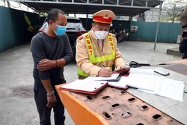 Lực lượng cảnh sát giao thông lập biên bản xử lý các trường hợp vi phạm trật tự an toàn giao thông. (Ảnh: Phạm Kiên/TTXVN)