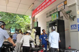 Nhân viên Petrolimex đang bán xăng cho khách hàng. (Ảnh: Đức Duy/Vietnam+)