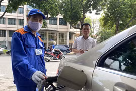 Nhân viên Petrolimex đang bán xăng cho khách hàng. (Ảnh: Đức Duy/Vietnam+)