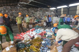 Lực lượng chức năng tiến hành tiêu hủy hàng giả. (Ảnh: Đức Duy/Vietnam+)