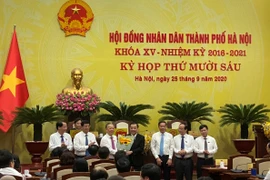 Các đại biểu tặng hoa chúc mừng ông Chu Ngọc Anh trúng cử chức Chủ tịch Ủy ban nhân dân thành phố Hà Nội nhiệm kỳ 2016-2021. (Ảnh: Xuân Quảng/Vietnam+)
