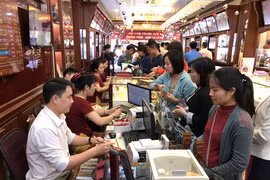 Khách hàng đang giao dịch vàng miếng. (Ảnh: Đức Duy/Vietnam+)