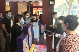 Đoàn liên ngành về An toàn thực phẩm thành phố phối hợp với quận Hai Bà Trưng kiểm tra một số cửa hàng kinh doanh bánh trung thu trên phố Bà Triệu. (Ảnh: Xuân Quảng/Vietnam+)