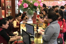 Khách hàng giao dịch vàng miếng. (Ảnh: Đức Duy/Vietnam+)