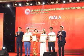 Bí thư Thành ủy Hà Nội Vương Đình Huệ và Chủ tịch Hội Nhà báo Việt Nam Thuận Hữu trao giải A cho các tác giả. (Ảnh: Đức Duy/Vietnam+)