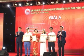 Bí thư Thành ủy Hà Nội Vương Đình Huệ và Chủ tịch Hội Nhà báo Việt Nam Thuận Hữu trao giải A cho các tác giả. (Ảnh: Đức Duy/Vietnam+)