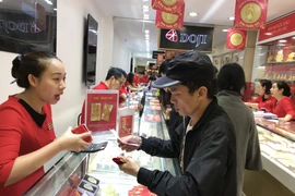Khách hàng đang giao dịch vàng miếng. (Ảnh: Đức Duy/Vietnam+)
