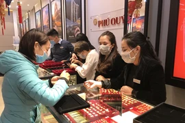 Khách hàng đang giao dịch vàng miếng. (Ảnh: Đức Duy/Vietnam+)