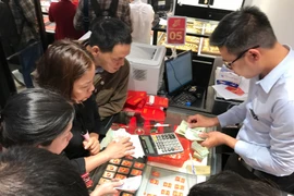 Khách hàng đang giao dịch vàng miếng. (Ảnh: Đức Duy/Vietnam+)