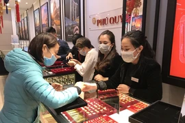Khách hàng giao dịch vàng miếng. (Ảnh: Đức Duy/Vietnam+)