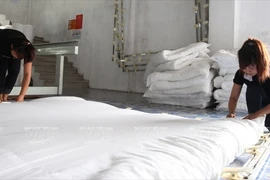 Công đoạn làm căng chăn bông trước khi đưa lên máy khâu.