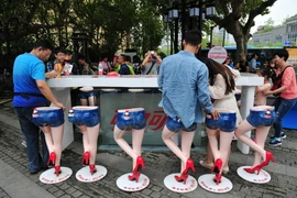 Người đi đường trải nghiệm cảm giác ngồi trên những 'cặp chân dài.' (Nguồn: QQ News)