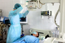 Diễn tập quy trình tiếp nhận, cách ly, theo dõi, lấy mẫu xét nghiệm, tiến hành các kỹ thuật cận lâm sàng chẩn đoán bệnh, chăm sóc và điều trị người bệnh nghi nhiễm MERS. (Ảnh: Dương Ngọc/TTXVN)