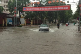 Đường Nguyễn Văn Cừ ngập sâu trong nước. (Ảnh: Văn Vĩnh/TTXVN)