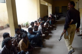 Cảnh sát Pakistan gác bên các ngư dân vừa bị bắt giữ tại Karachi ngày 6/3. (Nguồn: AFP/TTXVN) 