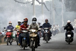 Người dân đi ngoài đường luôn phải bịt khẩu trang để tránh hít phải khói bụi. (Ảnh: Hoàng Hải/TTXVN)
