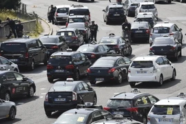 Các tài xế taxi chặn tuyến đường Porte Maillot trong cuộc biểu tình ở Paris. (Nguồn: AFP/TTXVN)