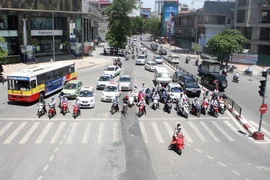 Dừng chờ đèn đỏ là một cực hình với người tham gia giao thông trong những ngày nắng nong. (Ảnh: Minh Quyết/Vietnam+)