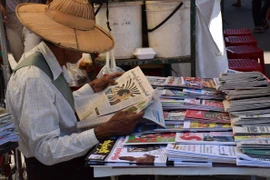 Người dân theo dõi báo chí viết về cuộc bầu cử. (Ảnh: Sơn Nam/Vietnam+)