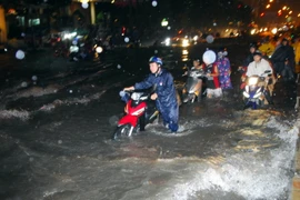 Đường Nguyễn Hữu Cảnh, phường 22, quận Bình Thạnh chìm sâu trong biển nước, hàng trăm phương tiện lưu thông bị chết máy. (Ảnh: Mạnh Linh/TTXVN)