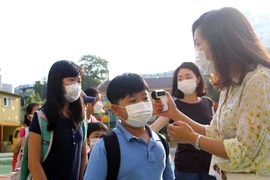 Kiểm tra thân nhiệt của các học sinh tiểu học ở thủ đô Seoul nhằm ngăn chặn lây nhiễm MERS. (Nguồn: THX/TTXVN)