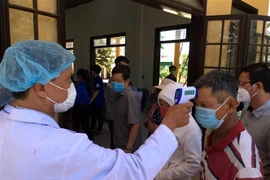 Hành khách đi trên những phương tiện giao thông tiến hành kiểm tra thân nhiệt, khai báo y tế tại chốt kiểm tra thị xã Hương Thủy, tỉnh Thừa Thiên-Huế. (Ảnh: Đỗ Trưởng/TTXVN)