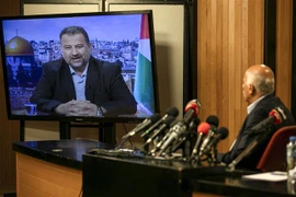 Quan chức cấp cao phong trào Fatah, Jibril Rajub (phải) tại thành phố Ramallah trong cuộc họp trực tuyến với quan chức phái Hamas, ông Saleh al-Arouri (trên màn hình) ở Beirut (Lebanon) ngày 2/7. (Ảnh: AFP/TTXVN)