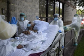Nhân viên y tế chuyển bệnh nhân COVID-29 tại trung tâm y tế ở Houston, Texas, Mỹ. (Ảnh: AFP/TTXVN)