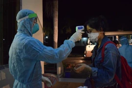 Kiểm tra sức khỏe, khám sàng lọc ban đầu cho công dân Việt Nam trở về từ nước ngoài. (Ảnh: Chương Đài/TTXVN)
