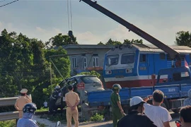 Đưa chiếc xe bị tai nạn ra khỏi hiện trường. (Ảnh: Nguyễn Chinh/TTXVN)