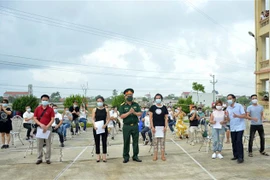 Trao giấy chứng nhận hoàn thành thời gian cách ly cho các công dân. (Ảnh: TTXVN phát)