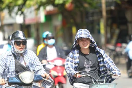 Thời tiết nắng nóng, tia UV ở mức cao, người dân cần trang bị tốt đồ bảo hộ khi ra đường để bảo vệ sức khỏe. (Ảnh: Thanh Tùng/TTXVN)