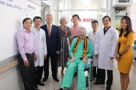 Bệnh nhân 91 chụp ảnh lưu niệm với đại diện Lãnh sự quán Anh tại Thành phố Hồ Chí Minh và các y bác sỹ trong ngày xuất viện. (Ảnh: TTXVN phát)