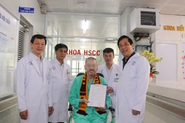 Lãnh đạo bệnh viện Chợ Rẫy trao giấy xác nhận xét nghiệm COVID-19 với kết quả 9 lần âm tính liên tiếp. (Ảnh: TTXVN phát)