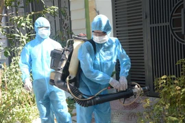 Phun thuốc khử trùng tại nhà trường hợp tiếp xúc gần với bệnh nhân nghi nhiễm COVID-19. (Ảnh: Văn Dũng/TTXVN)