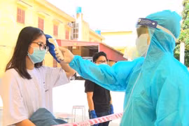 Kiểm tra thân nhiệt lần cuối cho người hoàn thành cách ly. (Ảnh: Đinh Tuấn/TTXVN)
