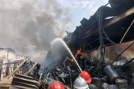 Lực lượng chức năng tiếp cận hiện trường, tích cực chữa cháy. (Ảnh: Nhật Anh/TTXVN)