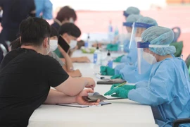 Lấy mẫu xét nghiệm COVID-19 cho người dân tại thị trấn Hallim, đảo Jeju, Hàn Quốc. (Ảnh: YONHAP/TTXVN)