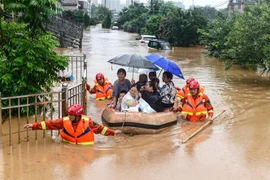Sơ tán người dân khỏi các khu ngập lụt tại tỉnh Giang Tây, Trung Quốc. (Ảnh: AFP/TTXVN)