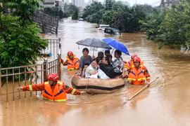 Sơ tán người dân khỏi các khu ngập lụt tại tỉnh Giang Tây, Trung Quốc. (Ảnh: AFP/TTXVN)