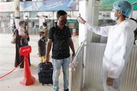 Nhân viên kiểm tra thân nhiệt của hành khách tại nhà ga tàu hỏa Kamlapur ở Dhaka, Bangladesh. (Ảnh: THX/TTXVN)